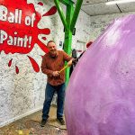 Scott applying a coat to the World's Largest Ball of Paint.