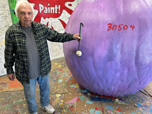 Mike holding a baseball next to the Ball of Paint for size comparison.